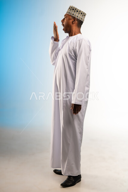 الإحساس بالتعب والتثاؤب, تعابير النعاس والحاجه الى النوم، بورتريه من الجانب لرجل عربي عماني خليجي يرتدي الكمه و الدشداشة يرفع يده على فمه بإيماءات النعاس, مفهوم الكسل والخمول، صورة الجسم بالطول الكامل, خلفيه ملونة