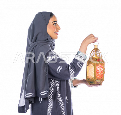 بورتريه لمرأة عربية خليجية سعودية ، تحمل بيدها فانوس ملون ، بإيماءات وجه ويدين مختلفة ، منظر جانبي لشابة سعودية مسلمة محجبة ترتدي العباءة الخليجية ، خلفية بيضاء ، العبادة والتقرب إلى الله ، فانوس رمضان