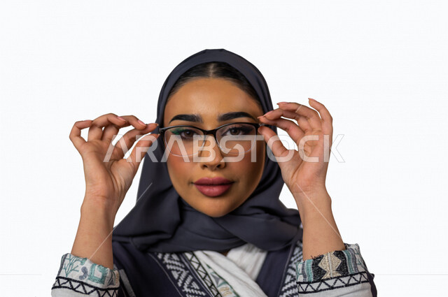 Portrait of a smiling Saudi Arabian Gulf woman looking at the camera, doing a photo session, with different facial and hand gestures, a veiled Saudi Muslim young woman wearing a Gulf abaya, white background