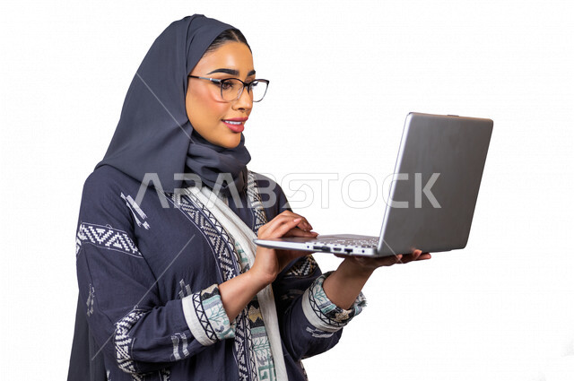 بورتريه لمرأة عربية خليجية سعودية ، إستخدام جهاز الحاسوب المحمول لإنجاز المهام ، العمل عن بعد ، سيدة أعمال ، إستخدام أجهزة تقنية حديثة ، شابة سعودية ترتدي العباءة الخليجية ، خلفية بيضاء ، التسويق الإلكتروني ، التعليم الإلكتروني ، مهن وأعمال