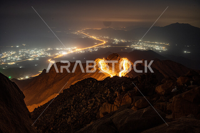 الطبيعة والبيئة الجبلية والقمم والمرتفعات في المملكة العربية السعودية، حركة مرور وسير السيارات على جبال الهدا في مدينة الطائف، طريق اسفلتي ملتوي وعر وسط الجبال الصخرية في منطقة عقبة الهدا في وقت الليل