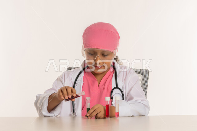 اجراء تجارب وتفاعلات حيويه في المختبر، بورتريه لفتاة عربية خليجية اماراتية ترتدي المعطف الأبيض ونظارات حماية وتستخدم انابيب الاختبار، بنت سعودية تقوم بأبحاث علمية، أمنية الحصول على مهنة الباحثة الكيميائية، اختيار المهنة المستقبلية منذ الصغر، خلفية بيضاء