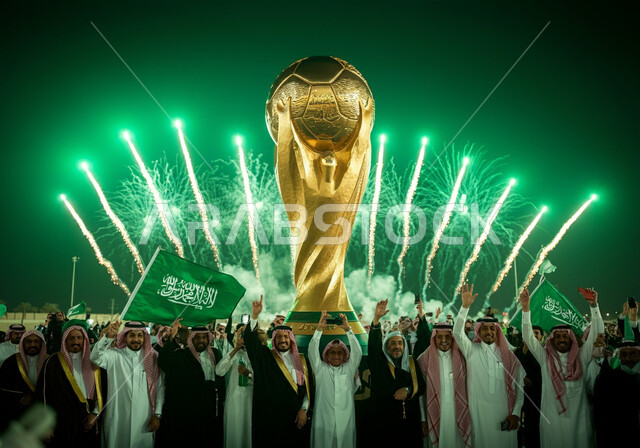 Interest in sports and recreational activities, celebrations of Saudi Arabia winning the bid to host the 2034 World Cup, a model of the golden World Cup for football, a group of Saudi Gulf Arab men wearing traditional dress launching firecrackers and fireworks at night