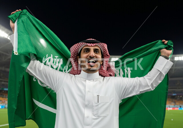 ايماءات الحماس والسرور، الاحتفال بالأعياد والمناسبات الوطنية، اليوم الوطني السعودي 23 سبتمبر, ذكرى يوم العلم 11 مارس، رجل عربي خليجي سعودي يرتدي الثوب التقليدي والشماغ يحمل علم المملكة ويقف في الملعب، تشجيع المنتخب السعودي،  الاهتمام بالرياضة والانشطة الترفيهية