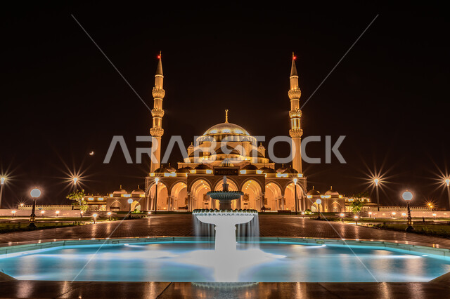 The illuminated Friday Mosque in Sharjah at night, the architectural art of building mosques in the Arab-Islamic style, the distinctive designs of domes and minarets, famous Islamic religious landmarks and places in the United Arab Emirates