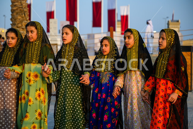 اليوم الوطني لدولة قطر 18 ديسمبر, الفخر والاعتزاز بالهوية القطرية, مفهوم الحب والانتماء للبلاد, مجموعة فتيات عربيات خليجيات قطريات ترتدين أزياء شعبية تحتفلن في إحدى فعاليات الدوحة, الاحتفال بالأعياد والمناسبات الوطنية