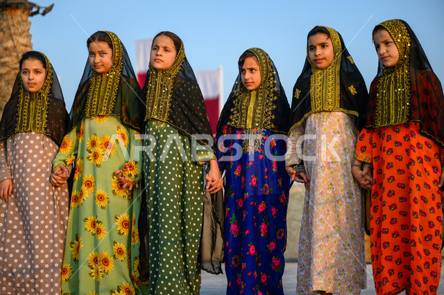 Celebrating national holidays and occasions, Qatar National Day December 18, Pride and appreciation for Qatari identity, Concept of love and belonging to the country, Group of Arab Gulf Qatari girls wearing traditional costumes celebrating at one of Doha's events