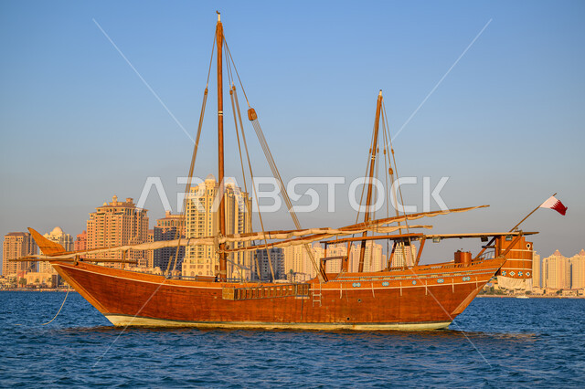 مهرجان كتارا الرابع عشر للمحامل، الواجهة البحرية في دولة قطر في النهار، أماكن سياحية لقضاء أوقات ممتعة، قارب خشبي وسط البحر على كورنيش مدينة الدوحة، الاستمتاع بالرحلات والنزهات البحرية الهادئة