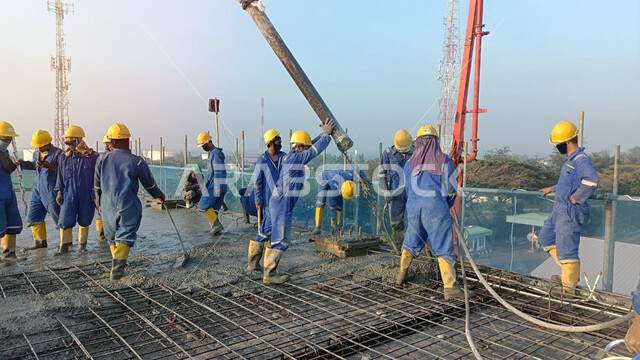 Implementation of the reconstruction plan, construction and building works in Saudi Arabia, establishing foundations and placing concrete, the concept of structural and architectural engineering, Saudi Gulf Arab workers wearing protective helmets performing the concrete finishing process