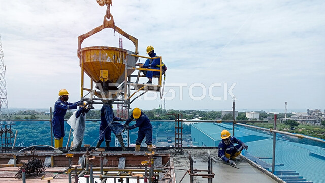 رافعة معدات خرسانية, أعمال التشييد والبناء في السعودية, إنشاء الأساسات ووضع الخرسانات, مفهوم الهندسة الانشائية والمعمارية, تنفيذ مخطط الإعمار, عمال عرب خليجيون سعوديون يرتدون خوذة الحماية يقومون برفع دلو الخرسانة
