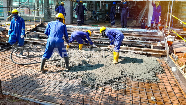 تنفيذ مخطط الإعمار, أعمال التشييد والبناء في السعودية, إنشاء الأساسات ووضع الخرسانات, مفهوم الهندسة الانشائية والمعمارية, عمال عرب خليجيون سعوديون يرتدون خوذة الحماية يقومون بعملية تشطيب الخرسانة