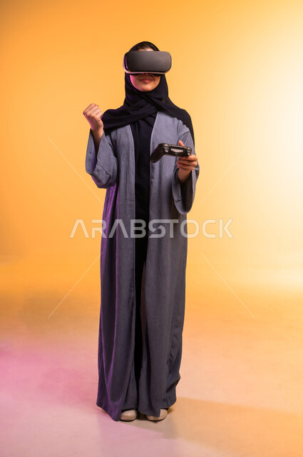 Digital transformation and technological progress, use of a modern and advanced technical device, portrait of a veiled Saudi Arabian Gulf woman wearing 3D glasses standing and holding a joystick in her hand, expressions and gestures of integration and focus in virtual reality, full-length body, colored background