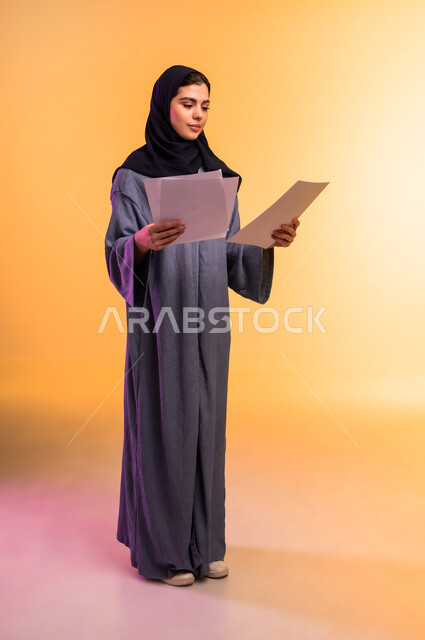 Proofreading written notes, preparing work reports, portrait of a veiled Saudi Arabian Gulf woman wearing an abaya holding white papers in her hand, reviewing and following up on plans and projects, exchanging experiences and skills, full-length body, colored background