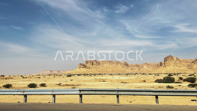 منظر السحب البيضاء في السماء، حافة نهاية العالم الصخرية في صحراء الرياض في المملكة العربية السعودية، معالم طبيعية اثرية سياحية مشهورة، الطبيعة الصحراوية والتضاريس الجبلية في السعودية، سلسلة جبال طويق في منطقة القدية