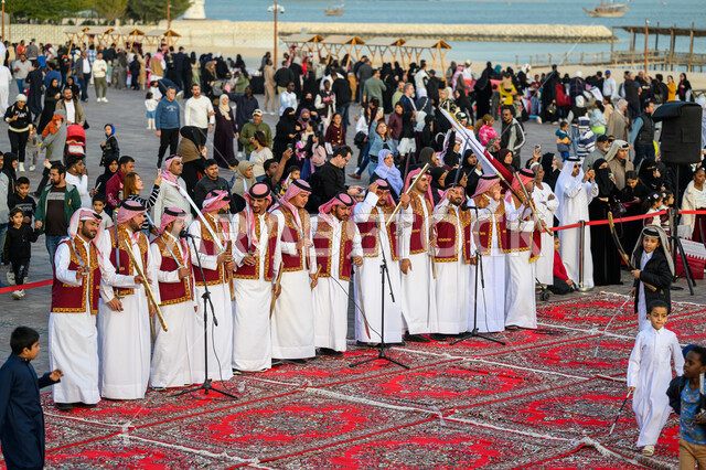 The concept of love and belonging to the country, popular heritage folklore, Qatari Gulf Arab men wearing traditional thobe and shemagh celebrating at one of the Doha events, national holidays and occasions, Qatari Ardah to celebrate Qatar National Day December 18