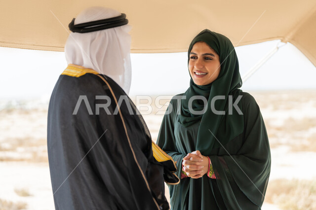 تأسيس الاتحاد 2 ديسمبر، صورة مقربة لرجل عربي خليجي إماراتي يرتدي الكندورة والغترة والبشت يقف مع إمراة ترتدي العباءة والحجاب داخل خيمة في الصحراء، ايماءات السعادة والسرور والاعتزاز، تبادل الاحاديث وزيارة الاماكن التاريخية القديمة، ذكرى اليوم الوطني الاماراتي 1971