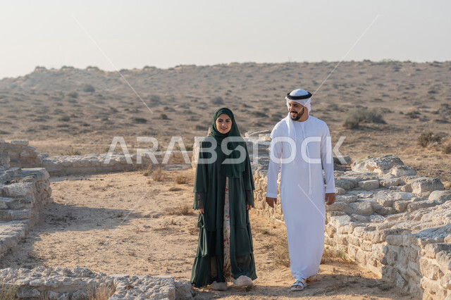 تأسيس الاتحاد 2 ديسمبر، شاب عربي خليجي إماراتي يرتدي الكندورة والغترة يتجول مع إمراة ترتدي العباءة والحجاب في منطقة أثرية في الصحراء، تعابير وايماءات الفخر والاعتزاز وحب الوطن، تبادل الاحاديث وزيارة الاماكن التاريخية القديمة، اليوم الوطني الاماراتي 1971