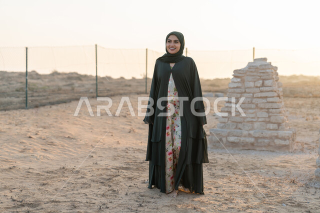 تأسيس الاتحاد 2 ديسمبر، الاحتفال بذكرى اليوم الوطني الاماراتي 1971، إمراة عربية خليجية إماراتية ترتدي الحجاب والعباءة تقف في منطقة اثرية تاريخية في الصحراء وقت النهار، حب الوطن والانتماء اليه، تعابير وايماءات الفخر والاعتزاز