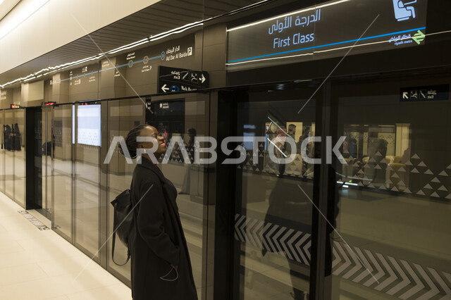 توفير خدمة التنقل الآمن, تقدم وتطور وسائل النقل والمواصلات البرية في المملكة العربية السعودية, سائحة أجنبية تقف أمام مدخل الدرجة الأولى للمترو في المحطة الجديدة في مدينة الرياض, مفهوم تسهيل الحركة المرورية في العاصمة