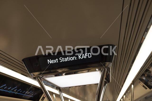 لوحة إعلانية تحمل عبارة الوجهة التالية مركز الملك عبد الله المالي كافد في محطة المترو الجديدة في مدينة الرياض, توفير خدمة التنقل الآمن، مفهوم تسهيل الحركة المرورية في العاصمة، تقدم وتطور وسائل النقل والمواصلات البرية في المملكة العربية السعودية