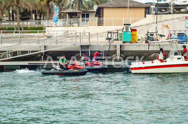 مجموعة من السفن والقوارب المائية في الميناء في النهار، جذب واستقطاب السياح من شتى أنحاء العالم، النقل البحري في مرسى دبي، النمو والتطور العمراني للمرافق التجارية والسكنية، مكان ومعلم سياحي مشهور، الواجهة البحرية الساحلية في دولة الإمارات العربية المتحدة