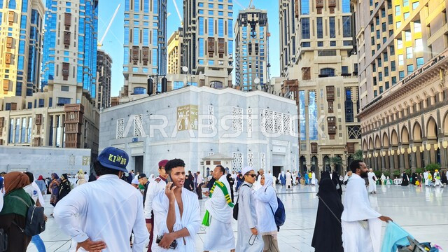 Pilgrims and Umrah performers gather in the courtyard of the Grand Mosque, Mecca, Saudi Arabia, performing Hajj and Umrah rituals, architectural art of the towers surrounding the Grand Mosque, sacred Islamic religious landmarks
