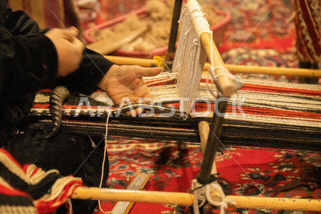 حرفة صنع المشالح في المملكة العربية السعودية، صناعة تقليدية شعبية، غزل الانسجة والقماش، صورة مقربة لايدي سيدة عربية خليجية سعودية تقوم بحياكة الخيوط، الفن التراثي الحرفي التقليدي