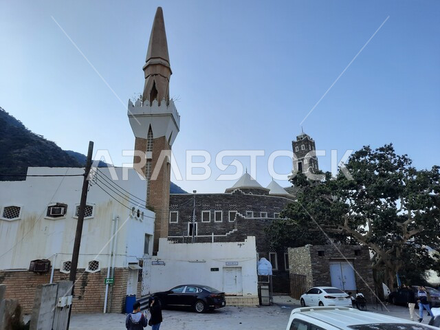 مسجد عتيق في قرية رجال ألمع التراثية في منطقة عسير في النهار، بيوت شعبية قديمة في المملكة العربية السعودية، الأماكن التاريخية السياحية، الفن الهندسي المعماري على الطراز التقليدي الاثري، جذب واستقطاب السياح من كافة انحاء العالم، مفهوم العبادة والصلاة والتقرب الى الله