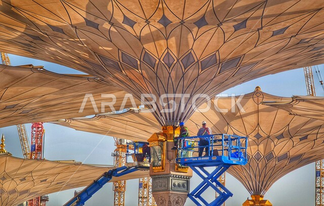 Worship and getting closer to God, electronic umbrellas in the courtyard of the Prophet's Mosque in Medina, Saudi Gulf Arab workers repairing the umbrella, Islamic holy places and landmarks in the Kingdom of Saudi Arabia