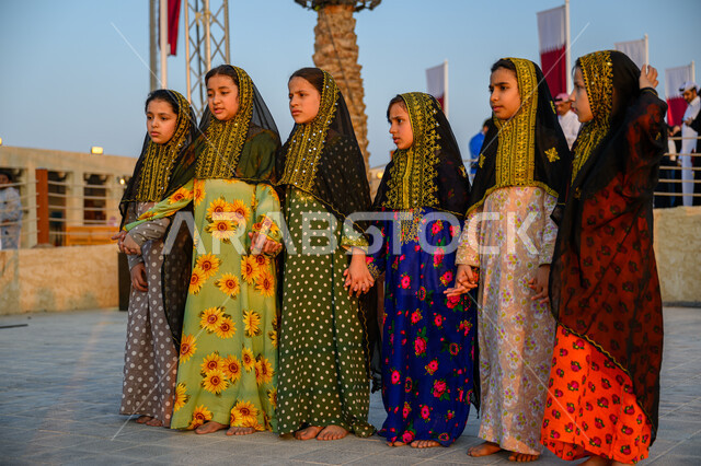 اليوم الوطني لدولة قطر 18 ديسمبر, الفخر والاعتزاز بالهوية القطرية, مفهوم الحب والانتماء للبلاد, مجموعة فتيات عربيات خليجيات قطريات ترتدين أزياء شعبية تحتفلن في إحدى فعاليات الدوحة, الاحتفال بالأعياد والمناسبات الوطنية