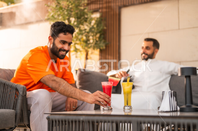 القيام بأنشطة ترفيهية الترويح عن النفس بلقاء الأصدقاء، تدخين الشيشة ضمن أجواء شبابية مسلية في كافيهات السعودية، قضاء أوقات ممتعة في الويكند، تناول العصائر الباردة المنعشة، شابان عربيان خليجيان سعوديان يجلسان معا في احد المطاعم ويتبادلان أطراف الحديث