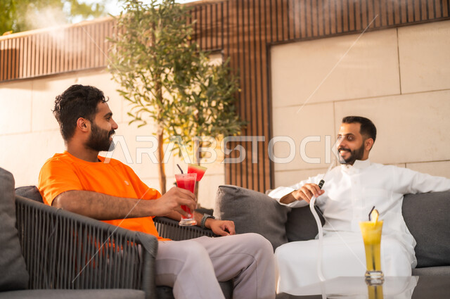 الترويح عن النفس والقيام بأنشطة ترفيهية برفقة الأصدقاء، تدخين الشيشة ضمن أجواء شبابية مسلية في كافيهات السعودية، قضاء أوقات ممتعة في الويكند، تناول العصائر الباردة المنعشة، شابان عربيان خليجيان سعوديان يجلسان معا في احد المطاعم ويتبادلان أطراف الحديث