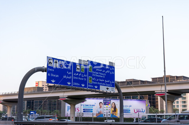 لافتة توجيهية في طريق الشيخ زايد في مدينة دبي في النهار، الاهتمام بالبنية التحتية، النمو والتقدم والتوسع العمراني، الطرق والمواصلات في الإمارات العربية المتحدة