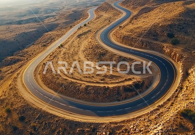 سلاسل الجبال والقمم والمرتفعات، الطرقات الجبلية الوعرة والمتعرجة, طريق اسفلتي معبد على سفح جبلي أعلى المنحدر، التضاريس والتشكلات الصخرية في صحاري المملكة، تسهيل سير السيارات والسفر والتنقل من مكان لآخر بين المدن، خلفية السماء عند الغروب