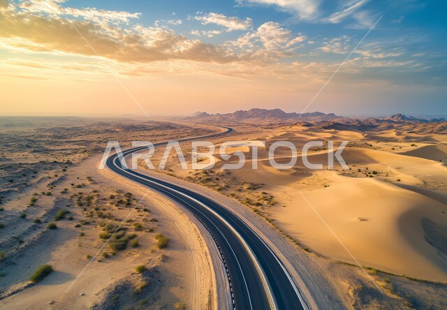 طريق اسفلتي معبد وسط الصحراء الواسعة، التضاريس والتشكلات الرملية في صحاري المملكة، تسهيل السفر والتنقل  بالسيارات من مكان لآخر، ربط المدن بالأرياف والمناطق النائية عبر الطرقات الحديثة، خلفية السماء الزرقاء نهارا