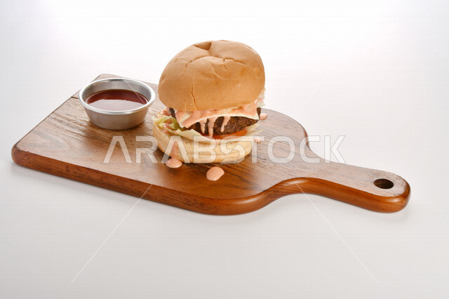 Delicious burger sandwich with layers of fresh meat and melted cheese with tomatoes and lettuce, Arabic food, delicious food recipes, fast food