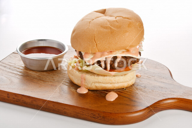 Delicious burger sandwich with layers of fresh meat and melted cheese with tomatoes and lettuce, Arabic food, delicious food recipes, fast food