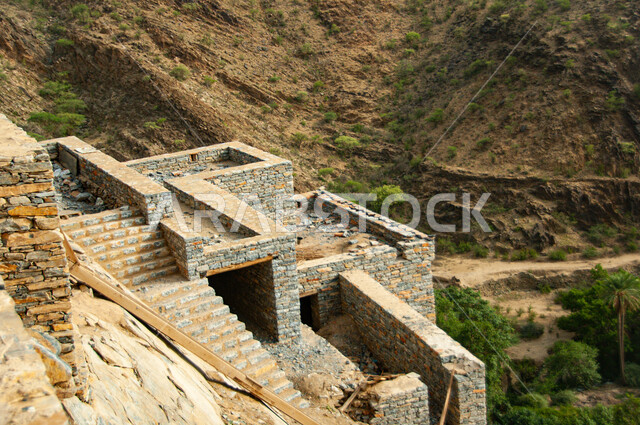 Ancient Arab architecture, rocky terrain, mountain peaks and heights, heritage stone buildings and houses, the ancient village of Dhi Ain in the city of Al Baha in the south of the Kingdom of Saudi Arabia, famous historical tourist attractions, natural places to attract and attract tourists