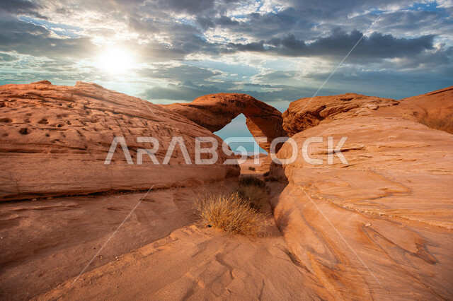 Ancient historical monuments, the famous Arch Rock in the desert areas of the Kingdom of Saudi Arabia, famous natural tourist places, rock formations and formations in the desert of Al-Ula Governorate, mountain peaks and heights in the middle of the sandy environment