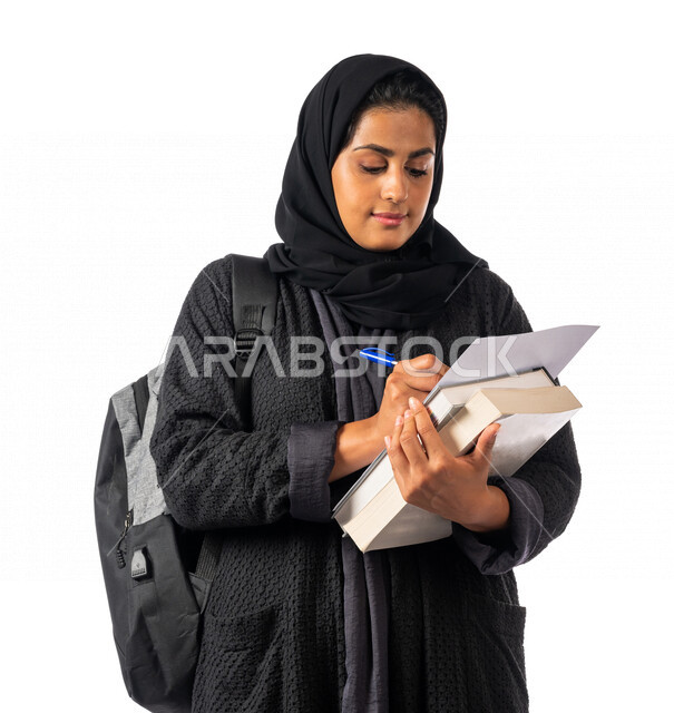 A Saudi Arabian Gulf university student tickets her university lectures, performing homework, enjoying studying, a diligent student, studying for exams, reading daily lessons, schools and universities, education in the Kingdom of Saudi Arabia