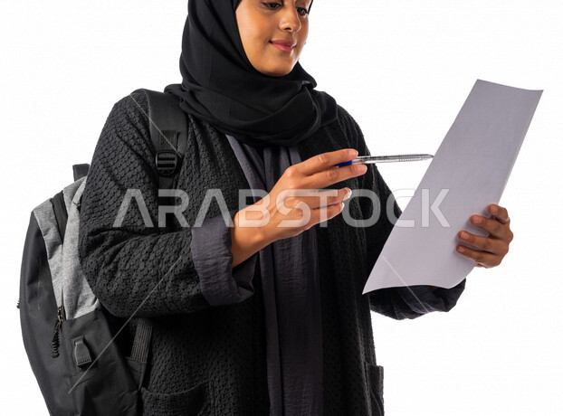 طالبه جامعيه عربيه سعوديه خليجيه تحمل بيدها ورقه وقلم, مراجعة ورقة عمل, طالبه مجتهده تذاكر دروسها, مدارس وجامعات, التعليم في المملكه العربيه السعوديه