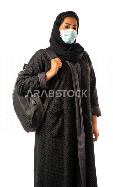 A Saudi Arabian Gulf university student carrying a university bag, preparing for the new academic year, obligating wearing a muzzle to avoid infection with the Corona virus, schools and universities, education in the Kingdom of Saudi Arabia