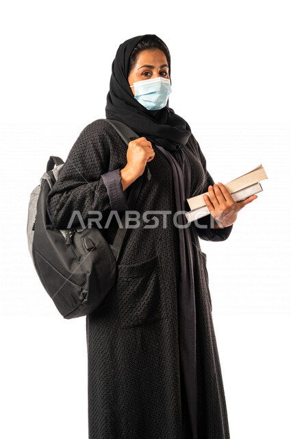 طالبه جامعيه عربيه سعوديه خليجيه تحمل الكتب والحقيبة الجامعيه, الاستعداد للعام الدراسي الجامعي الجديد, الالتزام بلبس الكمامه لتجنب الإصابه  بفايروس كورونا, مدارس وجامعات, التعليم في المملكه العربيه السعوديه