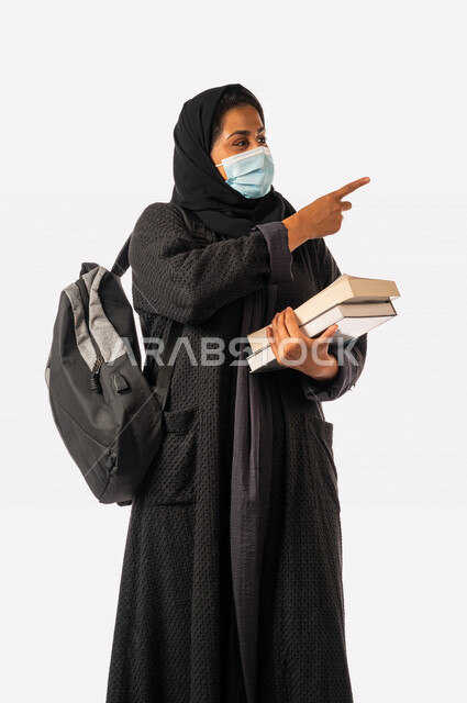 طالبه جامعيه عربيه سعوديه خليجيه تحمل الكتب والحقيبة الجامعيه, الاستعداد للعام الدراسي الجامعي الجديد, الالتزام بلبس الكمامه لتجنب الإصابه  بفايروس كورونا, مدارس وجامعات, التعليم في المملكه العربيه السعوديه