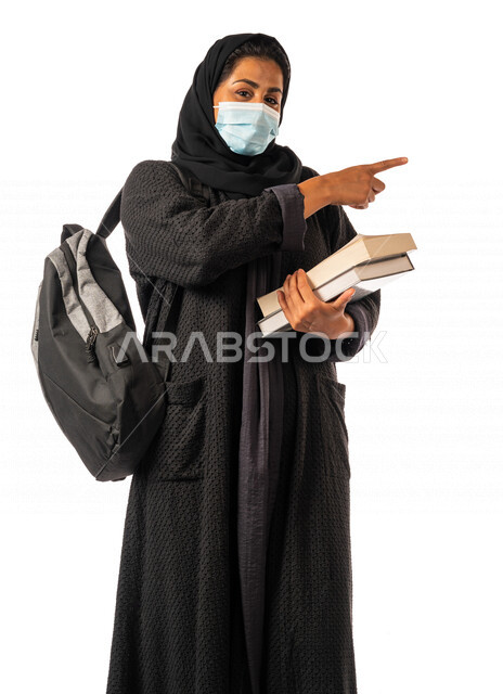 طالبه جامعيه عربيه سعوديه خليجيه تحمل الكتب والحقيبة الجامعيه, الاستعداد للعام الدراسي الجامعي الجديد, الالتزام بلبس الكمامه لتجنب الإصابه  بفايروس كورونا, مدارس وجامعات, التعليم في المملكه العربيه السعوديه