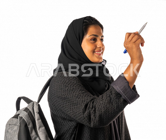 Portrait of a Saudi Arabian Gulf university student writing with a pen, solving homework, drawing with a pen, the development of science and education, schools and universities, education in the Kingdom of Saudi Arabia