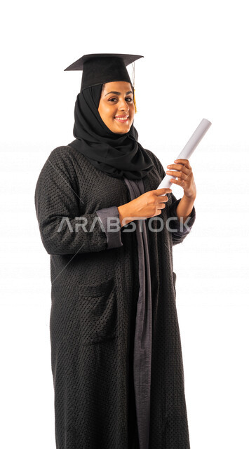 Portrait of an Arab Saudi Gulf university student holding her graduation certificate, facial and hands gestures indicating happiness with excellence and success, graduation ceremony, test results, outstanding student, schools and universities, education i