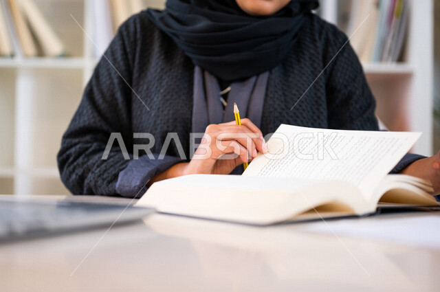 A Saudi Arabian Gulf student, studying university lectures, enjoying studying, performing homework, a diligent student studying in the university library, studying for exams, reading daily lessons, schools and universities, education in the Kingdom of Sau