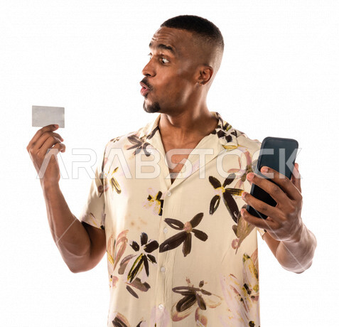 بورتريه لشاب أسمر عربي خليجي سعودي، الشراء والدفع من خلال برامج وتطبيقات الهاتف المحمول، امكانية تسديد الفواتير بالبطاقه الالكترونيه، ارتداء ملابس كاجوال، بشرة سمراء، خلفية بيضاء