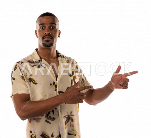 بورتريه لشاب عربي سعودي خليجي يقوم بايماءات يد مختلفة ويؤشر على يده الأخرى، شاب أسمر، ارتداء ملابس كاجوال، بشرة سمراء، خلفية بيضاء